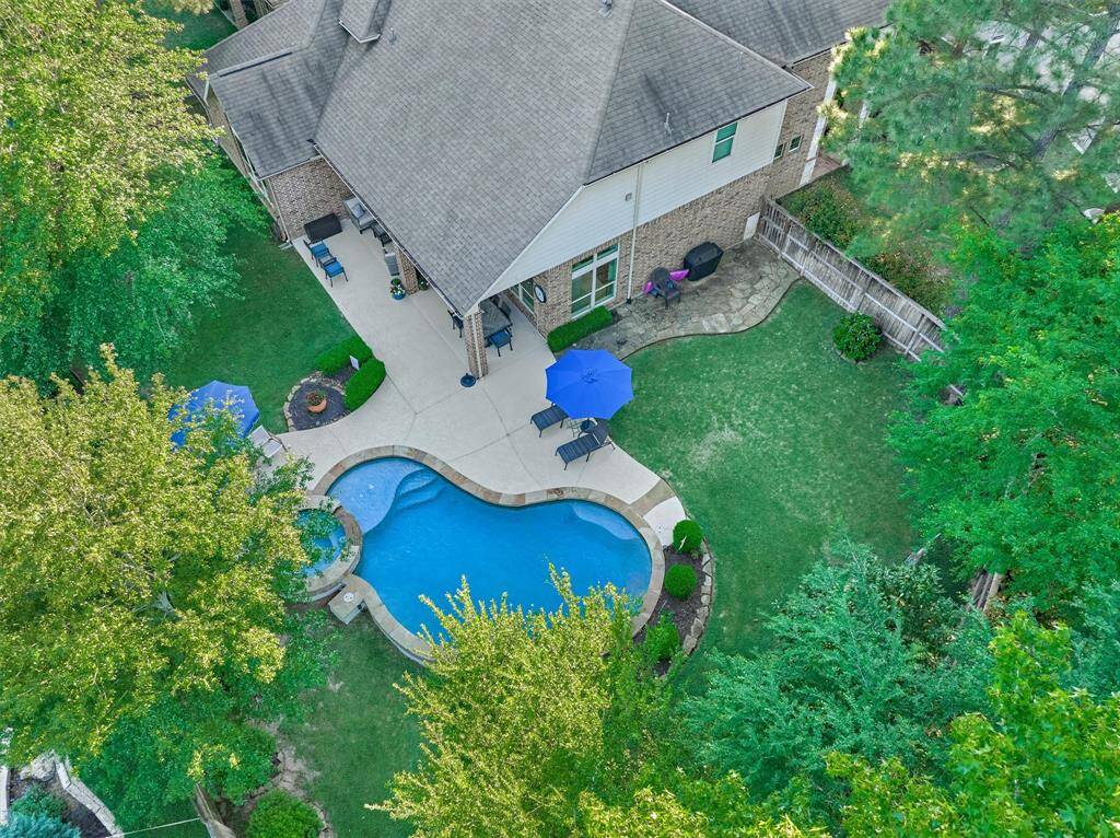 Backyard boasts a pool, spa & covered patio with ample yard space on either side