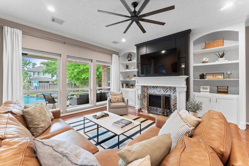 Relax and unwind in this warm and welcoming Family Room, where three sunny windows frame breathtaking views of the spacious backyard, covered porch, and salt-water pool/spa.