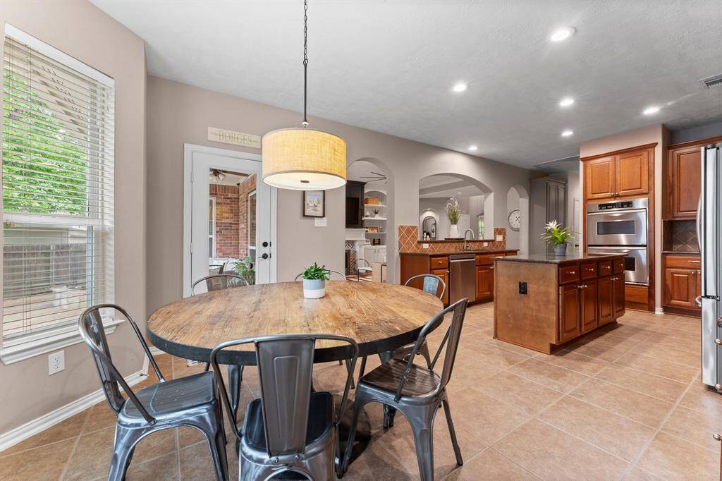 This gorgeous living and kitchen area is an entertainer’s dream! With an open floor plan, conversation flows effortlessly between the kitchen, den, and breakfast room—perfect for hosting or enjoying time with loved ones. Extra-large picture windows frame serene views, bringing in natural light and adding to the home’s inviting ambiance.
