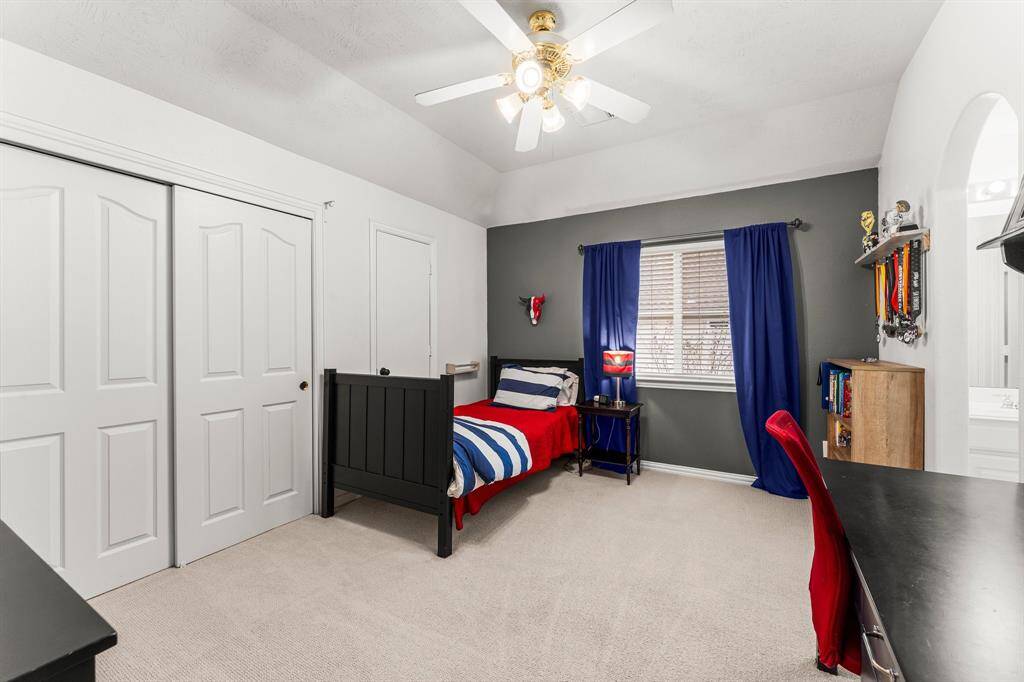 Four secondary bedrooms and two full baths are located on the second floor. This room features lush carpeting, sloped ceiling, large wall closet, sunny double window with blinds, and lighted ceiling fan. It also offers access to a floored attic storage area. It shares a Jack-and-Jill bath with Bedroom 3.