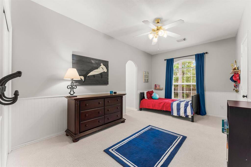Another secondary bedroom offers  lush carpeting, large wall closet, sunny arched window, beadboard wall detail, and lighted ceiling fan. It has direct access to a Jack-and-Jill bath shared with Bedroom 2. This room also has direct access to a small landing with a desk area which could be used for studying or gaming.