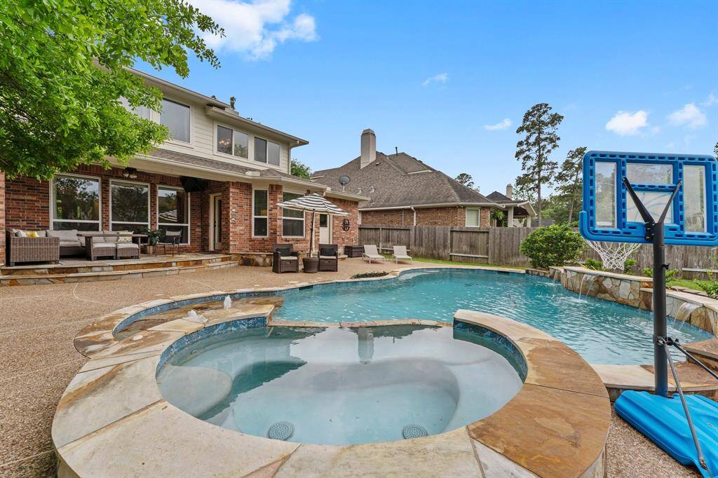 Before stepping inside, take a peek at this stunning backyard! Enjoy a covered porch with elegant flagstone flooring, a gorgeous saltwater pool and spa featuring three waterfalls, and a baja sunning shelf with relaxing bubblers. Plus, there’s a fabulous grassy area—perfect for play and outdoor fun!