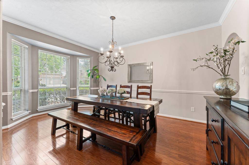 Gather your guests and celebrate in this stunning Formal Dining Room, designed for both grandeur and comfort. With plenty of space for a large dining table and full furniture suite, this room is perfect for any special occasion. It features wood flooring, bay window for natural light, elegant chair rail, crown molding, and a designer iron chandelier.