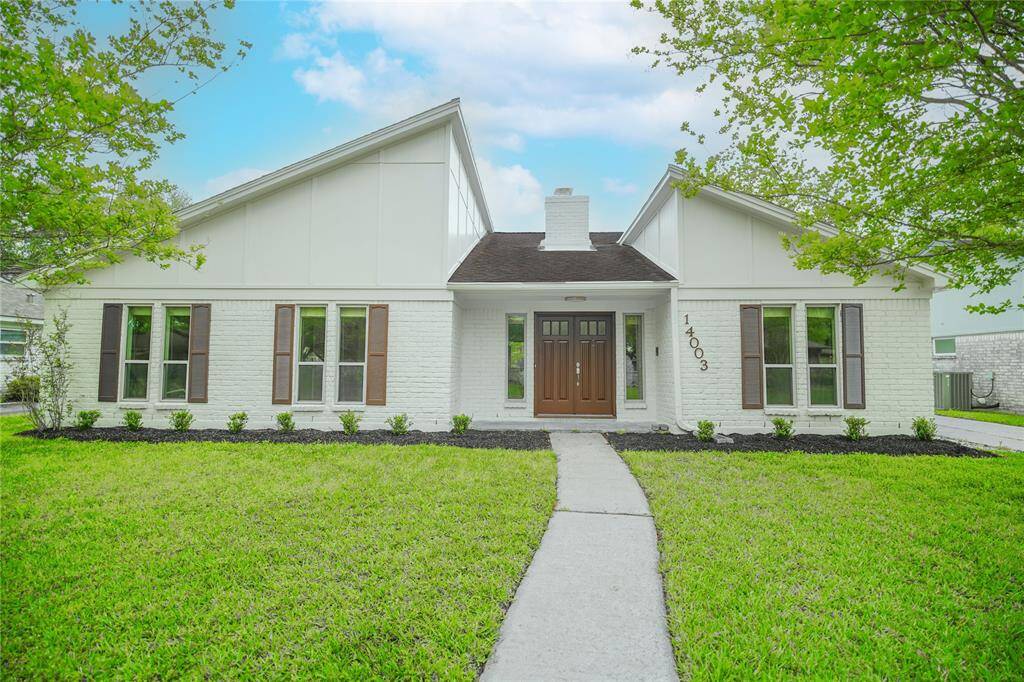 Welcome to 14003 Briarworth Dr. The exterior features whitewashed brick and siding, complemented by sleek landscaping and a hardwood entrance door.