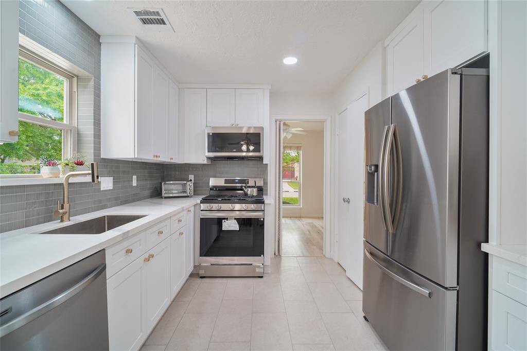 Renovated kitchen and breakfast nook. The Kitchen features soft-close hardwood cabinets all the way to the ceiling with quartz countertops and modern subway style backsplash. New tiles and new stainless steel appliances.