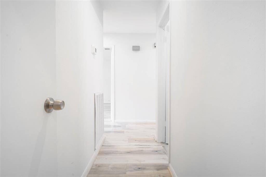 Hallway leading from the living area to the bedrooms and bathrooms.