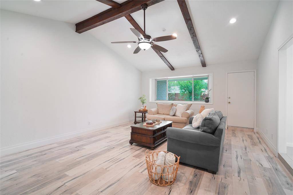 The open living area features a vaulted ceiling with exposed beams.