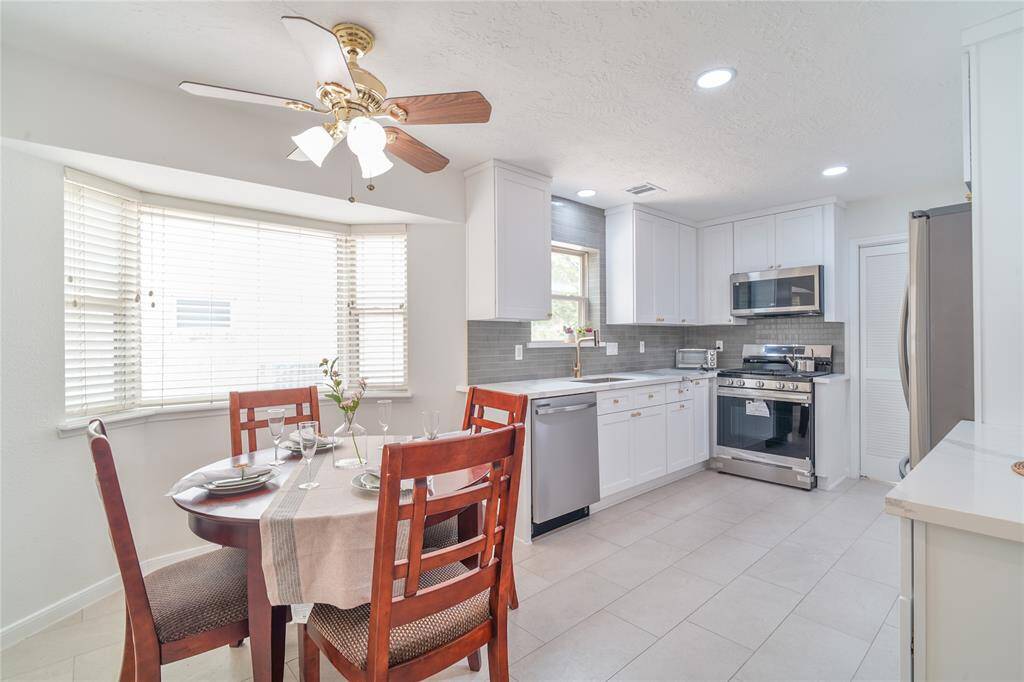 Renovated kitchen and breakfast nook. The Kitchen features soft-close hardwood cabinets all the way to the ceiling with quartz countertops and modern subway style backsplash. New tiles and new stainless steel appliances.