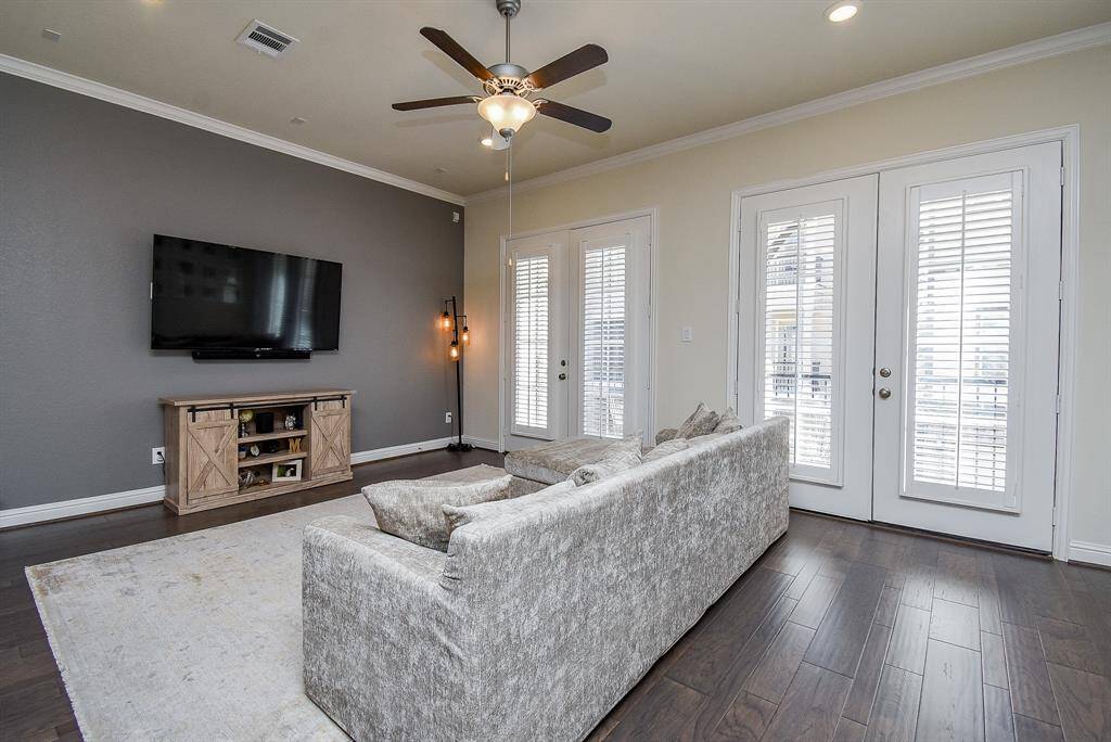 Spacious living room features crown molding and double set of French doors leading to huge balcony, perfect for enjoying your morning coffee! Note the upgraded shutters on the French doors.