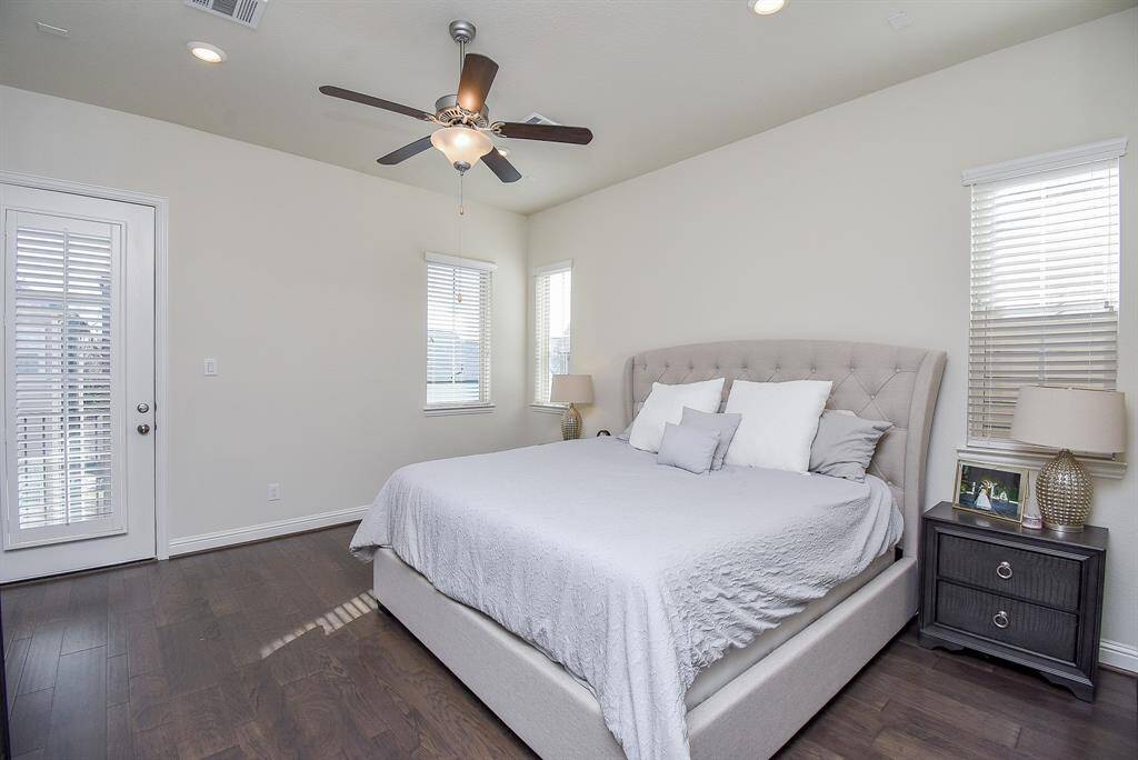 Primary bedroom features wood floors and private balcony.