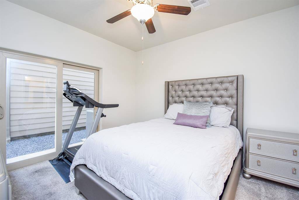 Spacious first floor secondary bedroom features sliding glass doors leading to the backyard.