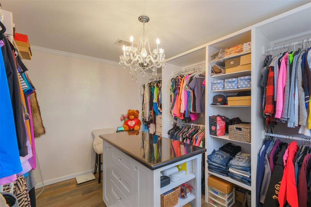 Dream closet with built-ins, center island, chandelier lighting, and tons of storage space!