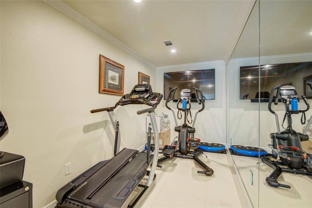 The workout room is equipped with a full mirrored wall, perfect for monitoring form and maximizing the workout experience.
