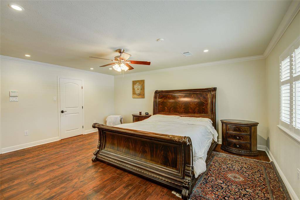 The large primary bedroom has picturesque backyard pool views.