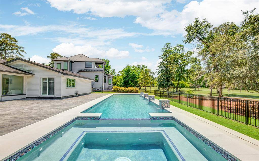 The stunning custom 65-foot lap pool with spa is surrounded by a spacious patio and overlooks the 5th hole on the Champions Cypress golf course.