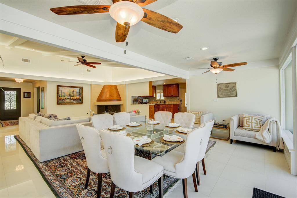 From the corner of the dining room, this view looks back toward the spacious family room, with the kitchen visible ahead at the center, emphasizing the vastness of the open floor plan.