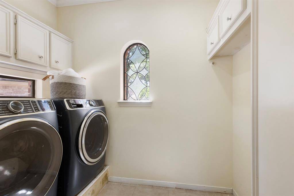 Spacious laundry room with beautiful windows that’ll make doing laundry feel a bit more enjoyable.
