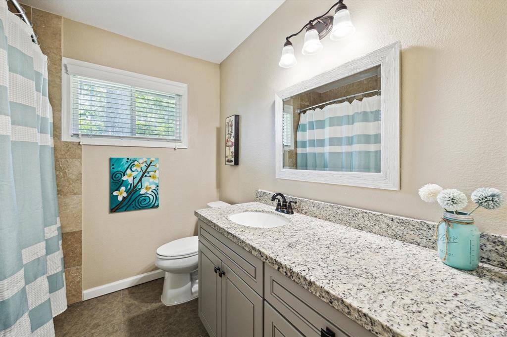 Secondary bathroom is nicely updated with granite counters and framed mirror - includes tub/shower combo.