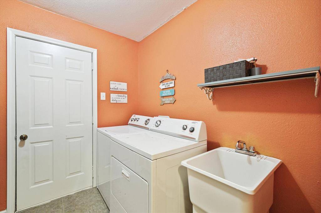 Great in-house laundry room with direct access to outside through the door ahead.  Includes soaking sink as well.