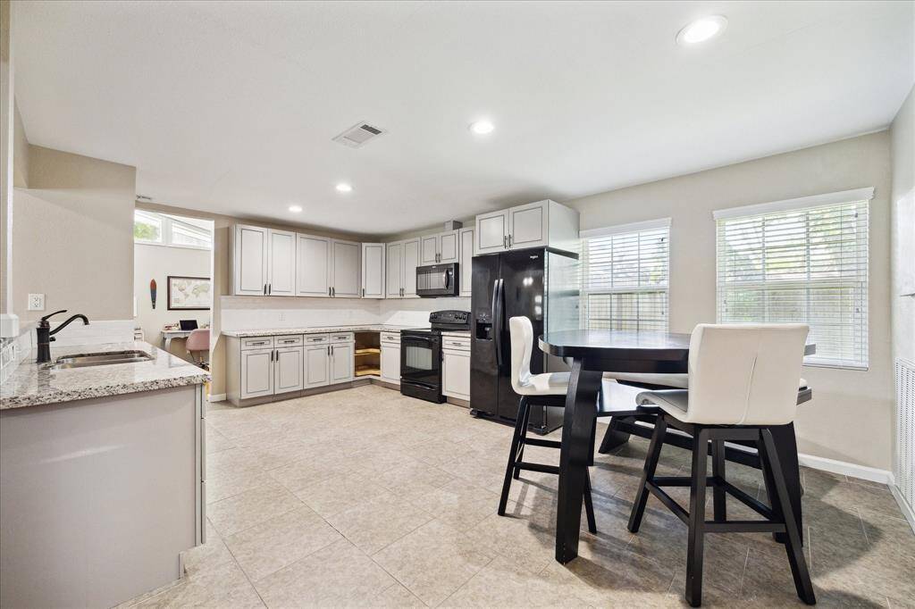 The light and bright kitchen includes granite counters, tile flooring and a cozy breakfast area overlooking the side yard.