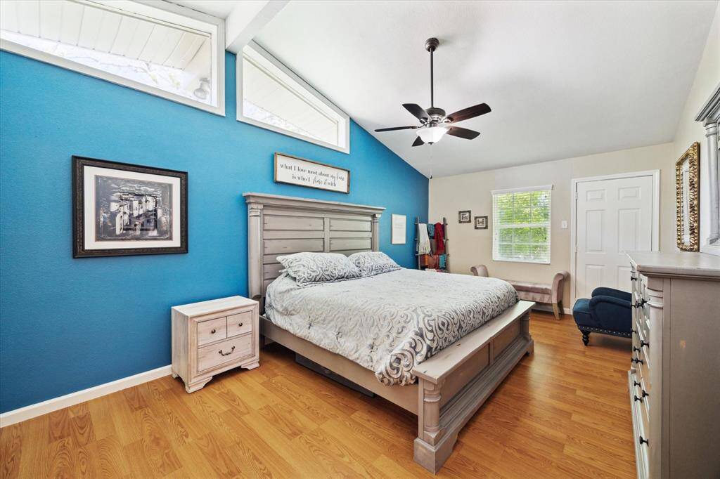 The primary bedroom is situated at the back of the residence and offers vaulted ceilings and separate access to the backyard.