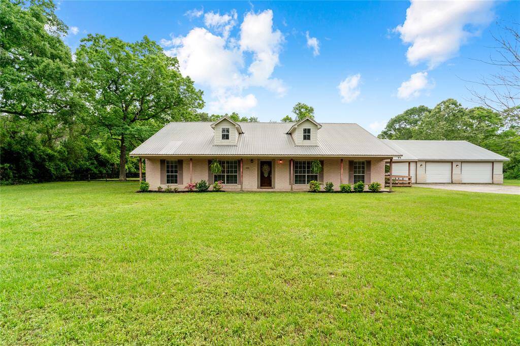 This well maintained 4-bedroom, 2-bath brick home sits on a manicured 2-acre corner lot. Featuring a large covered front porch, metal roof, and an attached 3-car garage with attic storage, the property combines practical layout with peaceful surroundings.