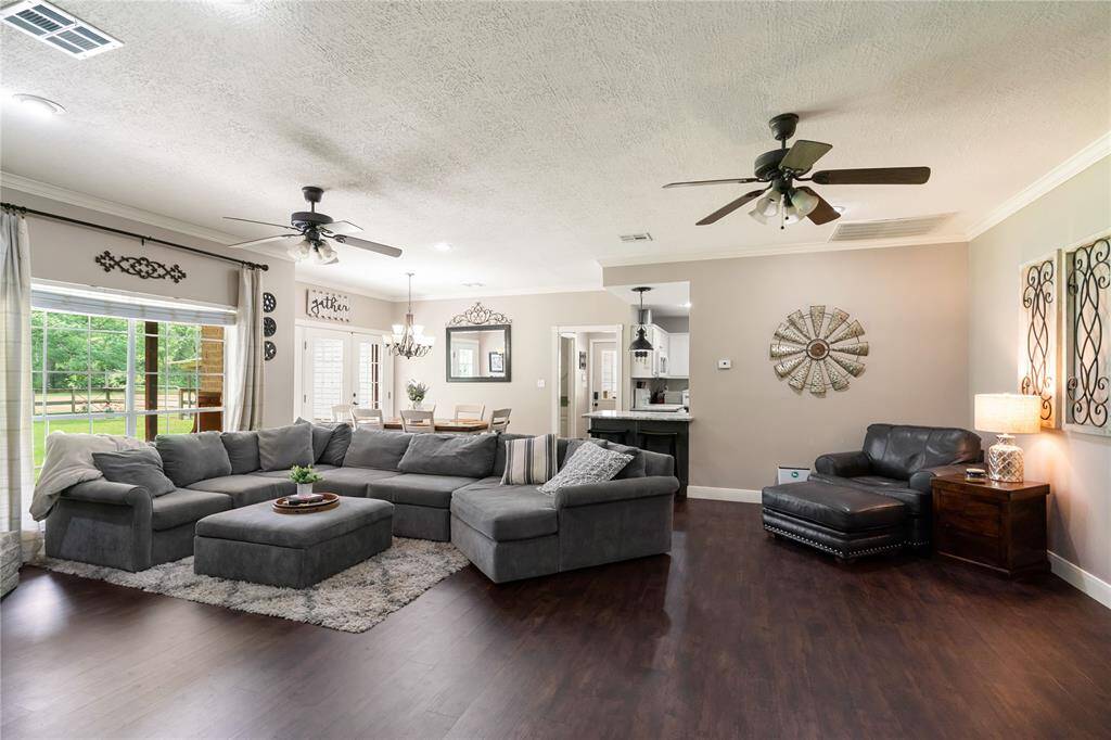 Generous living room layout with large windows and clear sightlines into the dining area and kitchen—ideal for entertaining or everyday living.