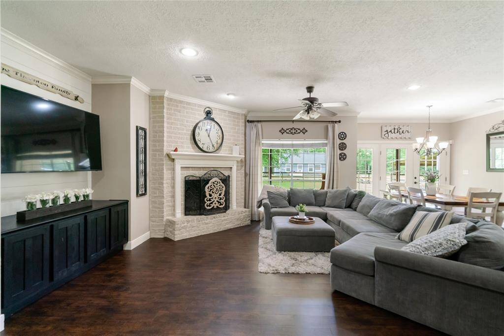 Brick-accented fireplace and custom media wall create a warm focal point, with recessed lighting and clean trim details throughout.