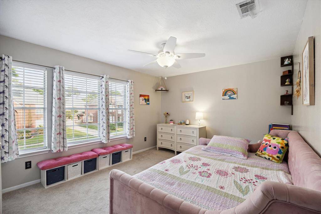 Guest bedroom one is very large with loads of natural light and a ceiling fan.