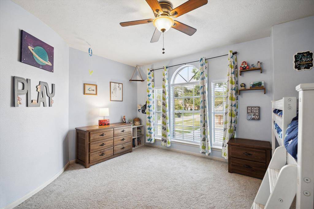 Guest bedroom number two is also large and inviting with plenty of natural light and a ceiling fan.