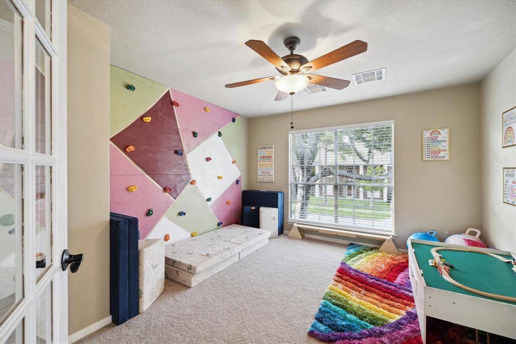 Have a need for five or more bedrooms? Here is guest bedroom number five, complete with a custom built rock wall. This home is kind of a child's paradise as well. With the study downstairs, this room has a total of six potential bedrooms.