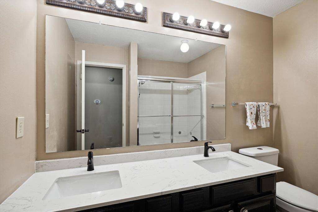 The freshly renovated guest bathroom with double sinks and a tub/shower combo.