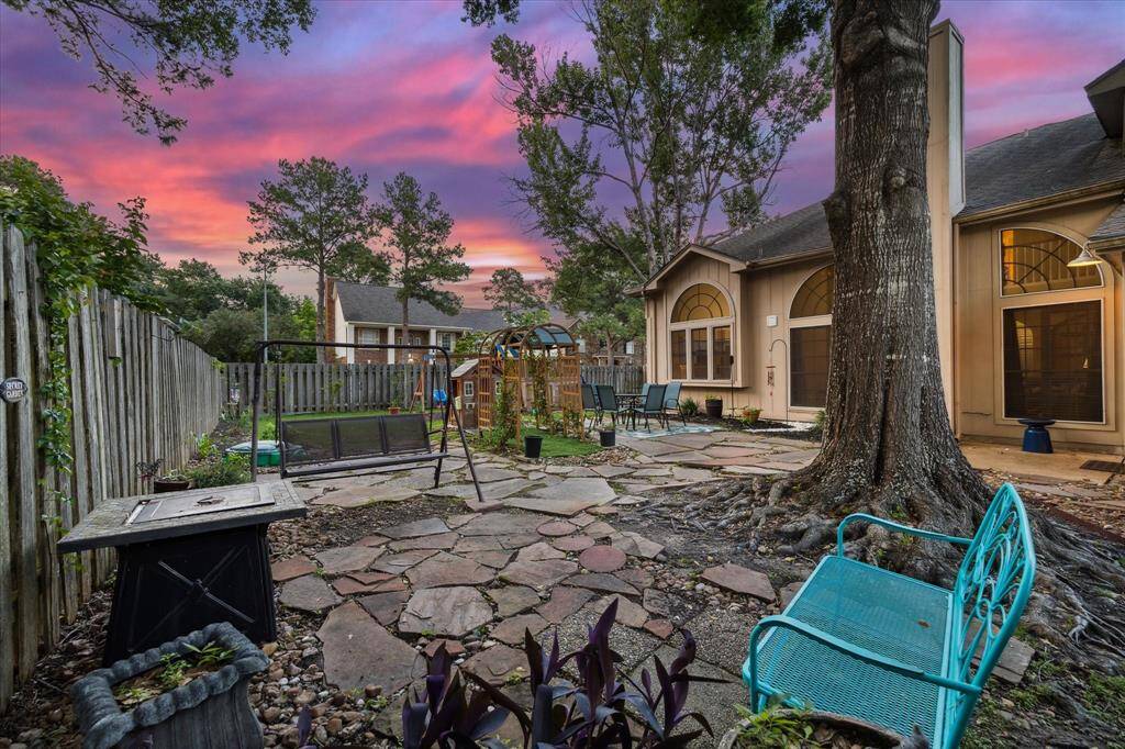 Firepit, huge flagstone patio, and mature trees make this backyard an oasis.