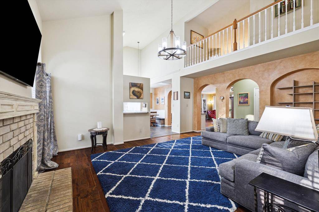 Open to the kitchen, the den includes the same elegant wood flooring, soaring ceilings, and is open to the catwalk above. Come down for dinner already!