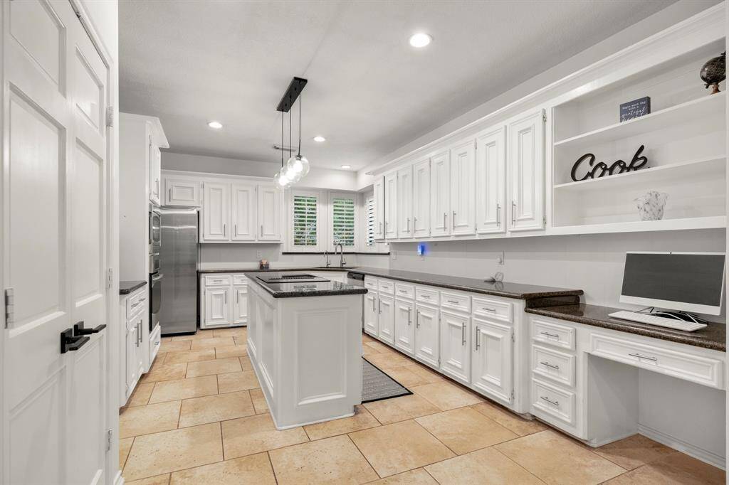 Stepping back, we see a built-in desk area in the kitchen, complete with shelves above for additional storage or display. To the left, the pantry is conveniently located next to the wine storage, offering easy access to both.