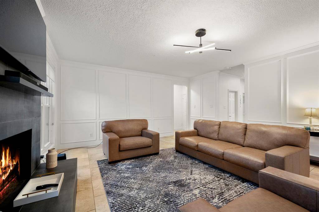 From this angle near the breakfast room, the living room reveals the doorway to the half bath, conveniently located across from the staircase in the foyer. The doorway across the living room leads to the primary suite, offering easy access to your private retreat.