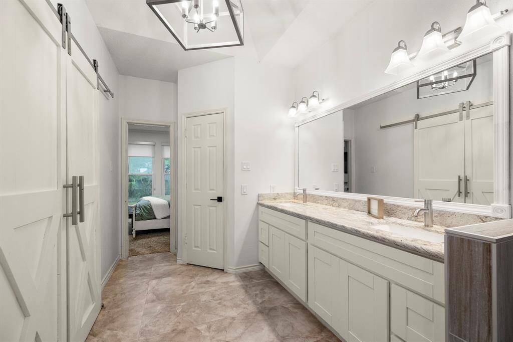 A look back at the bathroom from inside the shower shows the spacious layout, with the doorway on the right leading to the private water closet, offering added privacy and convenience.