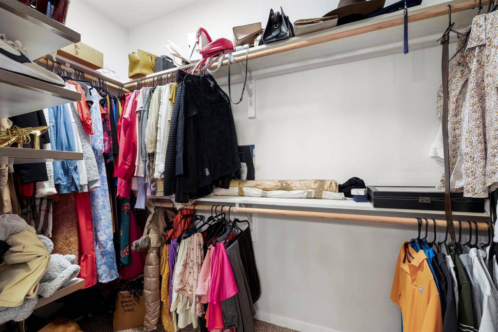 Another view inside the walk-in closet shows the spacious storage area to the left, providing ample room for organizing your wardrobe with ease and convenience.