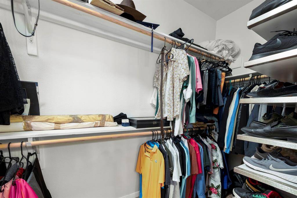 The view inside the walk-in closet to the right reveals even more spacious storage, offering plenty of room for organizing and displaying your wardrobe, shoes, and accessories.