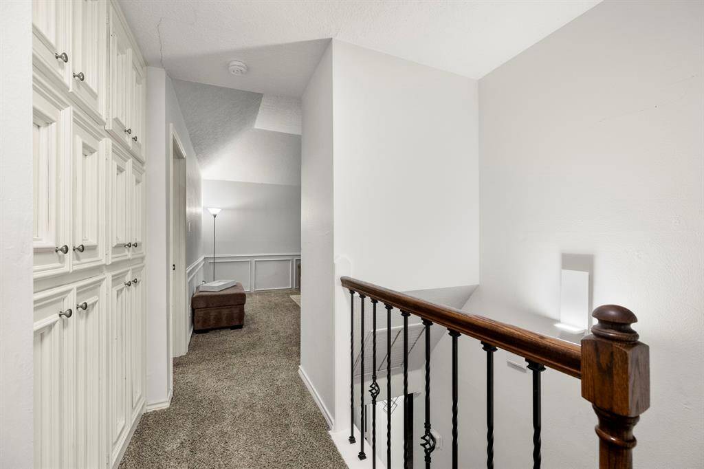 As we head upstairs, built-in storage along the way provides practical organization solutions. Approaching the game room, the space feels open and ready for a variety of uses, offering plenty of room to entertain or relax.