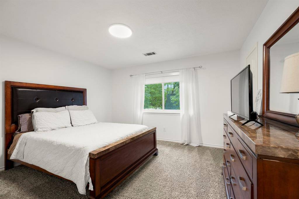 One of the upstairs bedrooms features a spacious walk-in closet, providing ample storage space. The room is filled with natural light, creating a comfortable and inviting atmosphere for rest or relaxation.