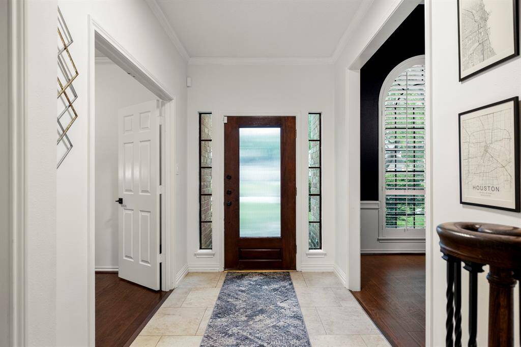 Looking back from the foyer, the home office is to the left, offering a private workspace, while the formal dining room is to the right, perfect for gatherings. Natural light pours in through windows on both sides of the front door, creating a bright and welcoming entry.