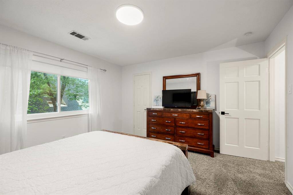 Another view inside the same upstairs bedroom shows the spacious layout, with the walk-in closet clearly visible. The room is bright and open, offering plenty of space for furniture and personal touches, creating a versatile and cozy retreat.