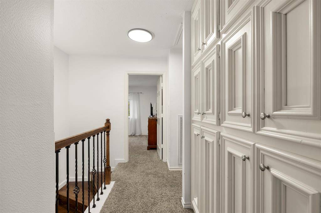 A close-up view of the built-in storage upstairs highlights the efficient use of space, offering convenient shelves and cabinets for easy organization. This thoughtful design keeps the area tidy while adding to the home's functionality.