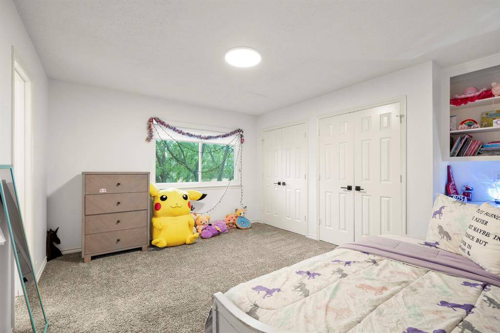 Another view of the same upstairs bedroom showcases the two closets and built-in desk area, highlighting the room's versatility. The space is well-lit and offers plenty of room for both relaxation and productivity, making it an ideal retreat or workspace.