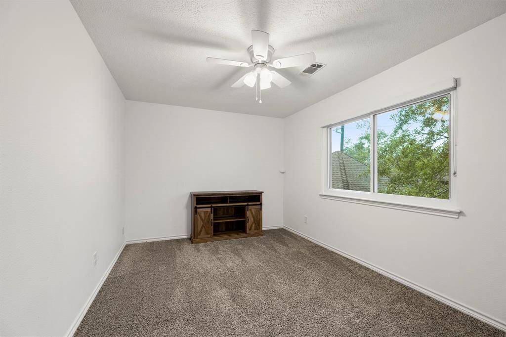 Another view of the connecting bedroom upstairs shows its spacious layout and natural light, creating a welcoming atmosphere. With plenty of room for furniture and personal touches, this room offers flexibility for various uses, making it a comfortable space to relax or work.