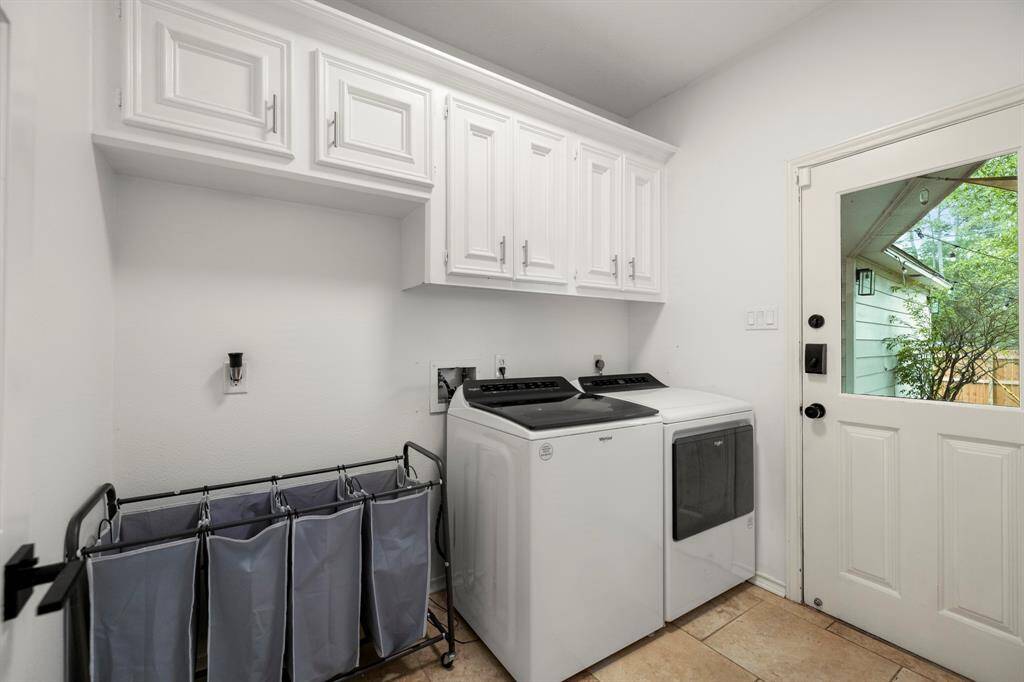 The downstairs laundry room features built-in storage and dedicated fridge space, providing both convenience and organization. An exterior door leads to the back patio, making it easy to step outside and enjoy the backyard or bring in groceries.