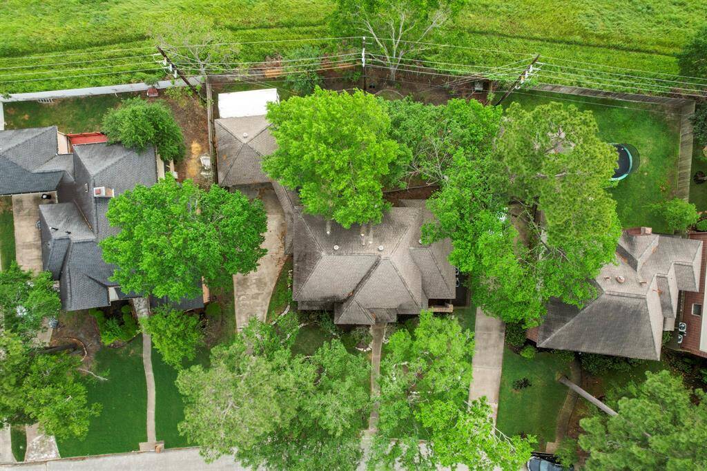 An aerial view of the home and lot showcases the property's spacious layout, including the well-maintained yard, detached garage, and driveway. The surrounding area is clearly visible, offering a full perspective of the property's size and its prime location within the neighborhood.