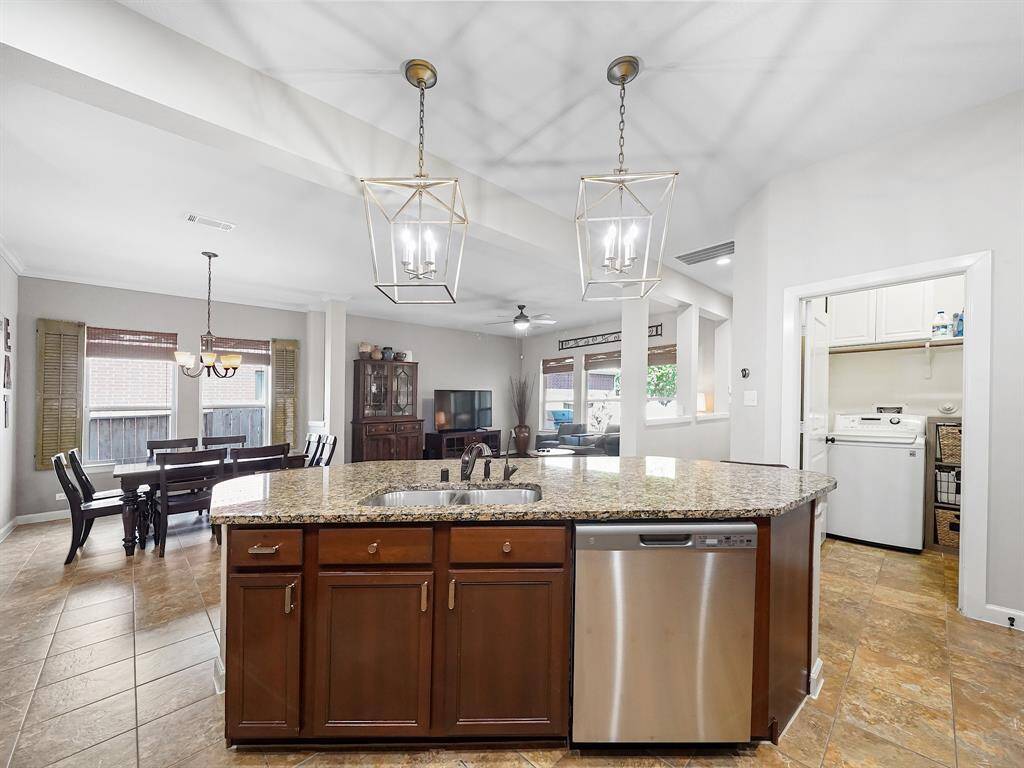 The kitchen seamlessly flows into the spacious dining area and the inviting living room, creating an open and airy floor plan perfect for both intimate gatherings and grand celebrations.