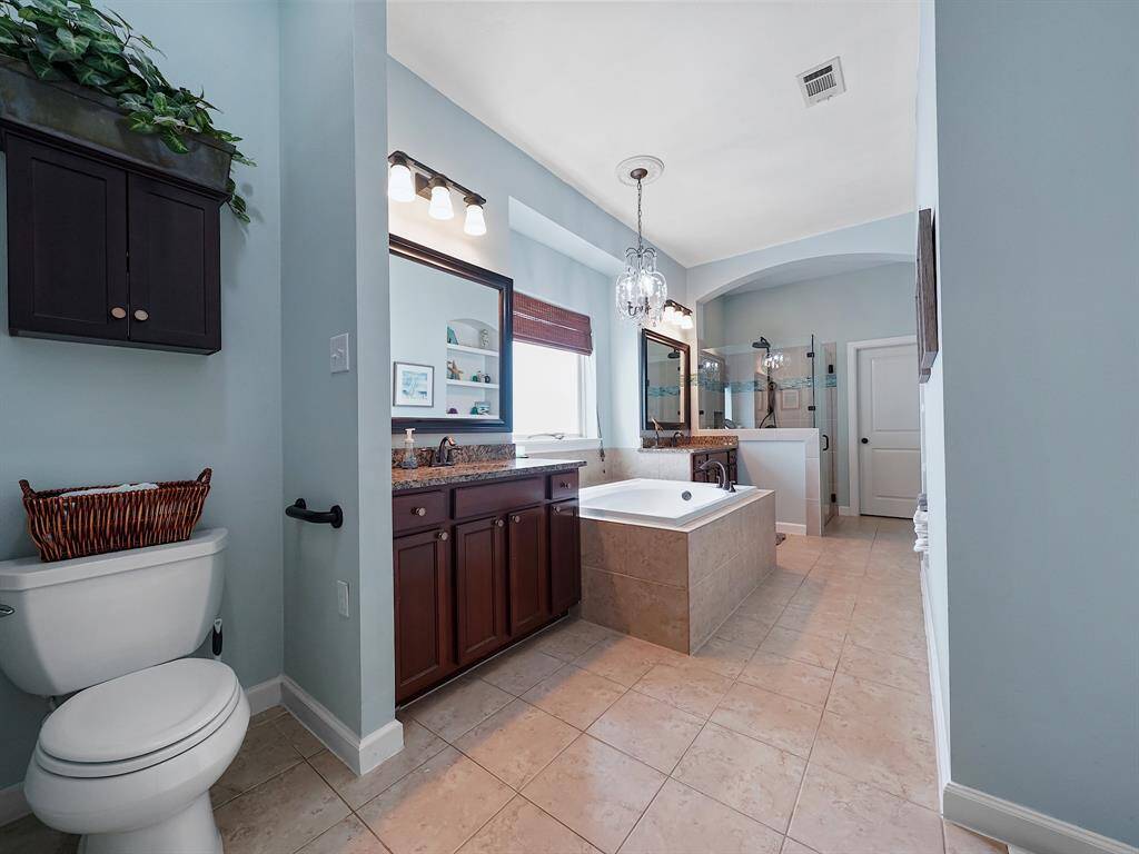 The spa-like ensuite bathroom is a true oasis, featuring a relaxing soaking tub, a separate shower, and dual vanities with sinks.